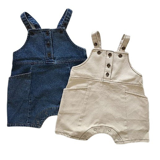 Two baby rompers in blue and beige cotton, featuring front buttons, straps, and pockets.
