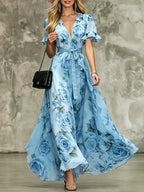 Women's deep V-neck ruffle sleeve printed maxi dress with high waist by Plush Fashion Hub, showcasing flowing fabric and vibrant print.