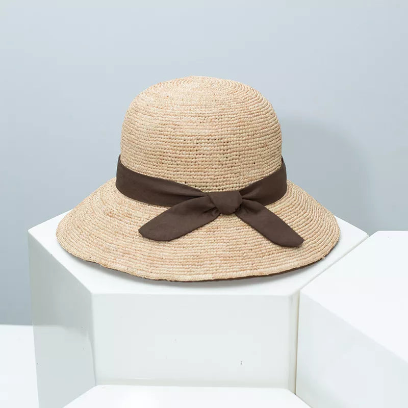 Women's straw sun hat with wide brim and ribbon detail, stylish summer accessory by Plush Fashion Hub.