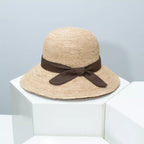 Women's straw sun hat with wide brim and ribbon detail, stylish summer accessory by Plush Fashion Hub.