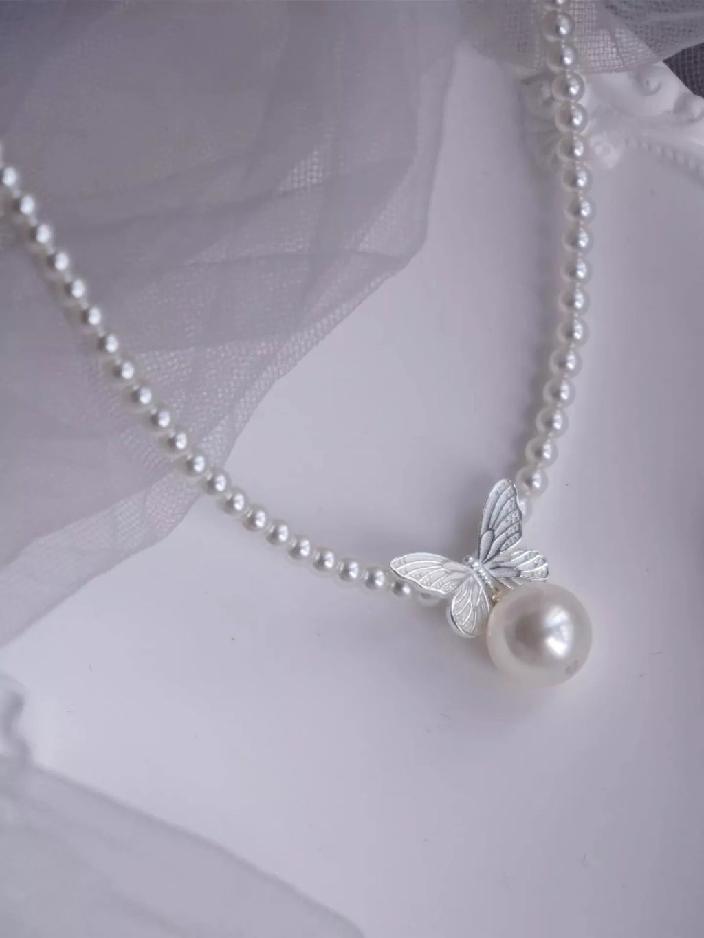 Pearl butterfly pendant necklace by Shopimist featuring a delicate pearl butterfly charm on a silver chain.
