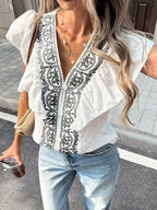 Ruffled V-neck blouse by Shopimist featuring soft fabric, feminine ruffles, and a stylish V-neck design, worn on a model.
