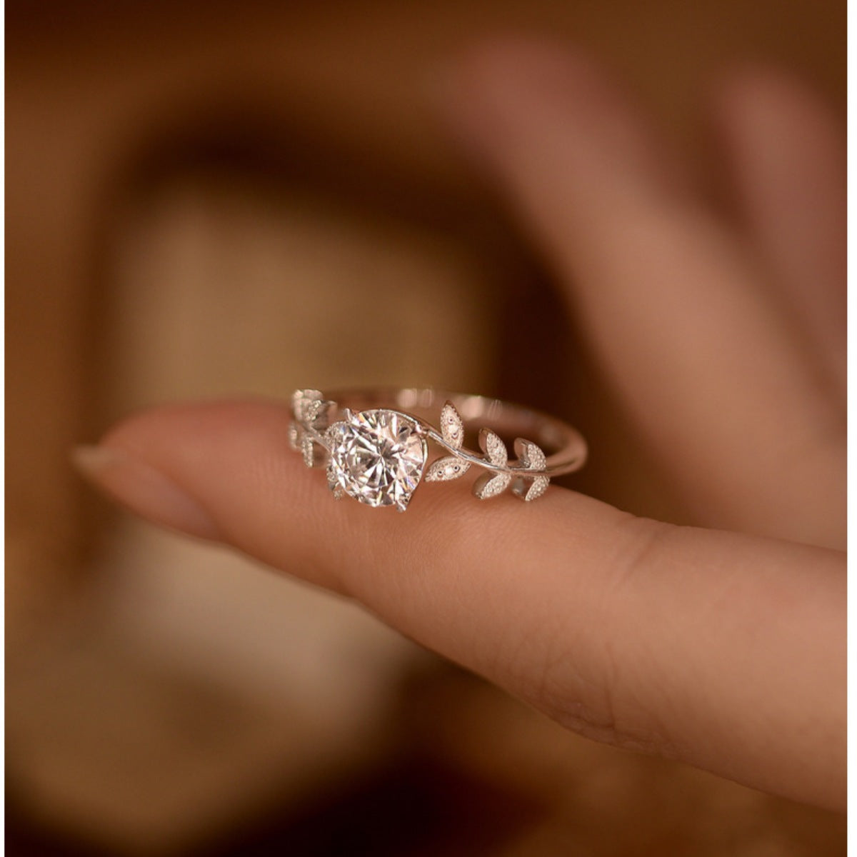 Sterling silver leaf ring with 1 carat moissanite gemstone, elegant jewelry with detailed leaf design.
