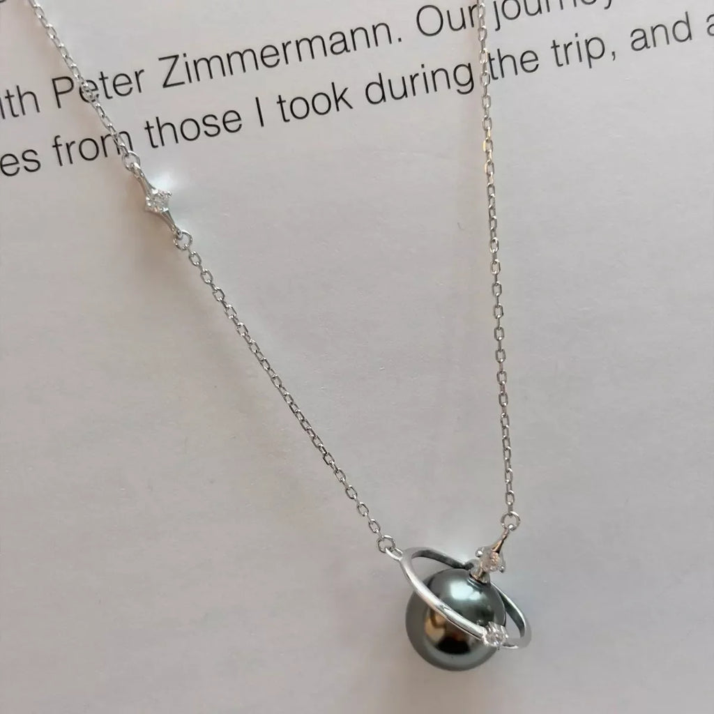 Planet Pearl Pendant Necklace by Shopimist featuring a shimmering pearl pendant on a delicate chain.