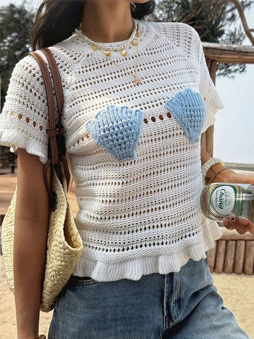Openwork ruffled hem knit top from Trendsi featuring a stylish openwork design and feminine ruffled hem detail.