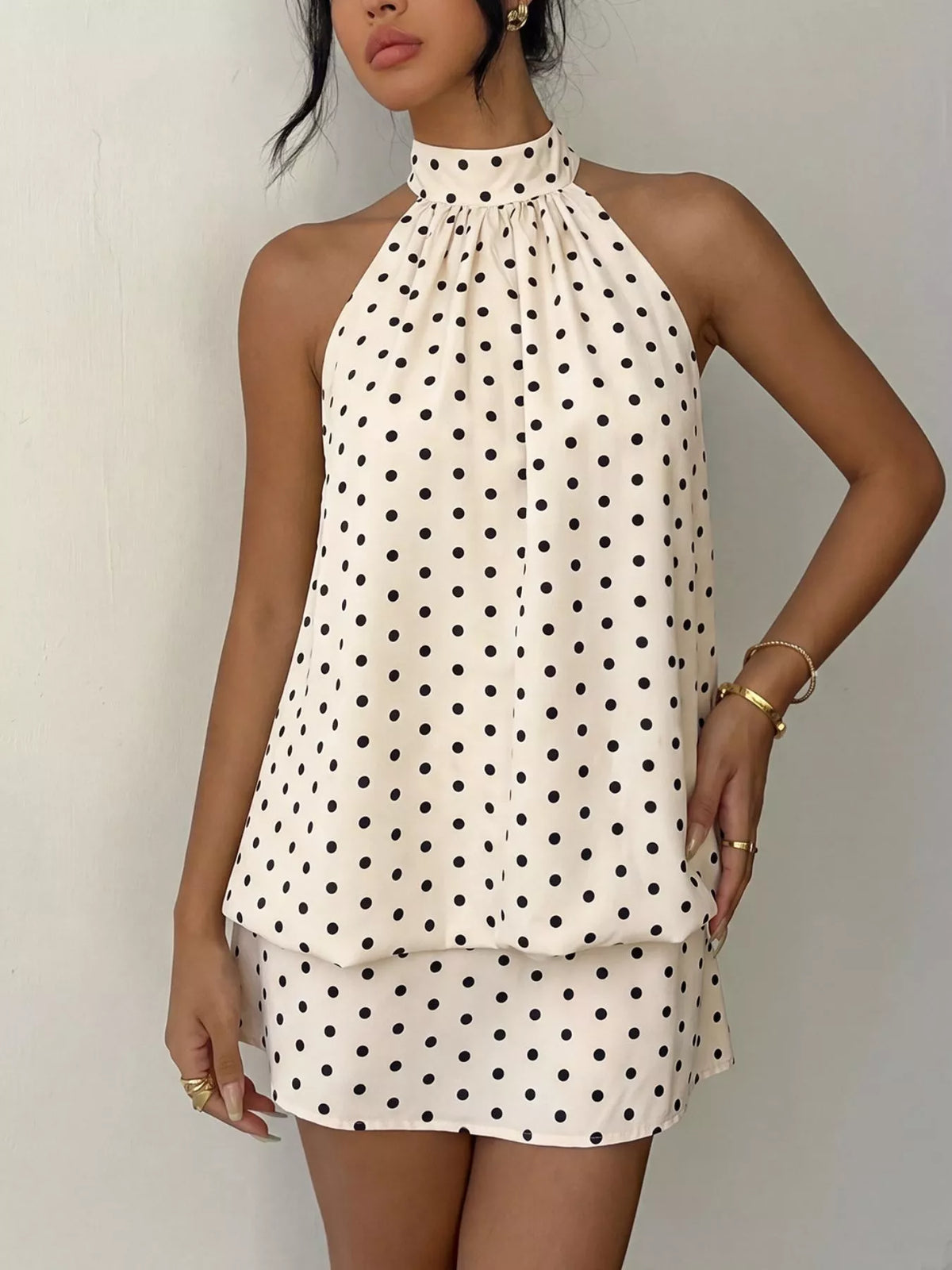 Polka dot halter neck mini dress by Plush Fashion Hub, featuring a stylish design with a fitted bodice and flared skirt.