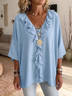 Plus size ruffle v-neck blouse with 3/4 sleeves by Trendsi, featuring a stylish design and feminine ruffle details.