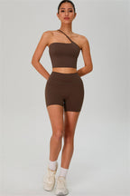 Fitglutes activewear one-shoulder crop top and matching shorts 2-piece set for workout and gym wear, shown in black fabric.