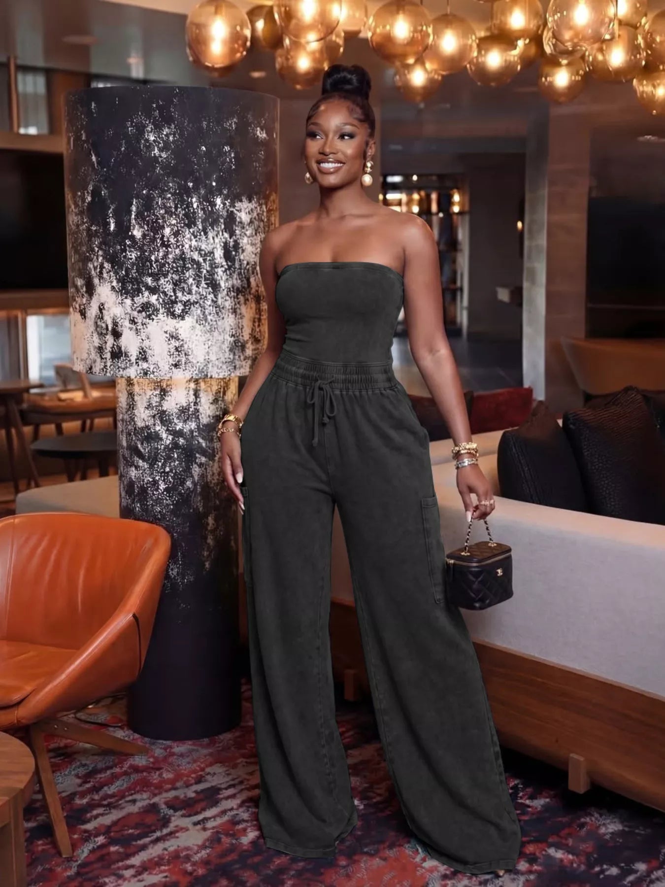 Strapless wide-leg jumpsuit with drawstring waist in black, from Plush Fashion Hub, styled with a fitted bodice and flowing pants.