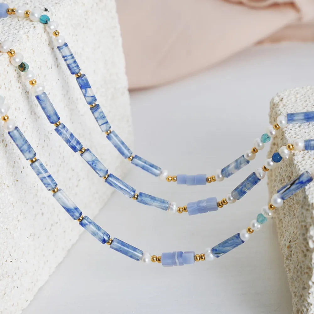 Freshwater pearl and geometric bead necklace made of titanium steel, stylish jewelry piece with modern design.