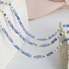 Freshwater pearl and geometric bead necklace made of titanium steel, stylish jewelry piece with modern design.