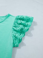 Ruffled eyelet lace cap sleeve top with cutout detail, trendy women's blouse by Trendsi featuring feminine design and lightweight fabric.