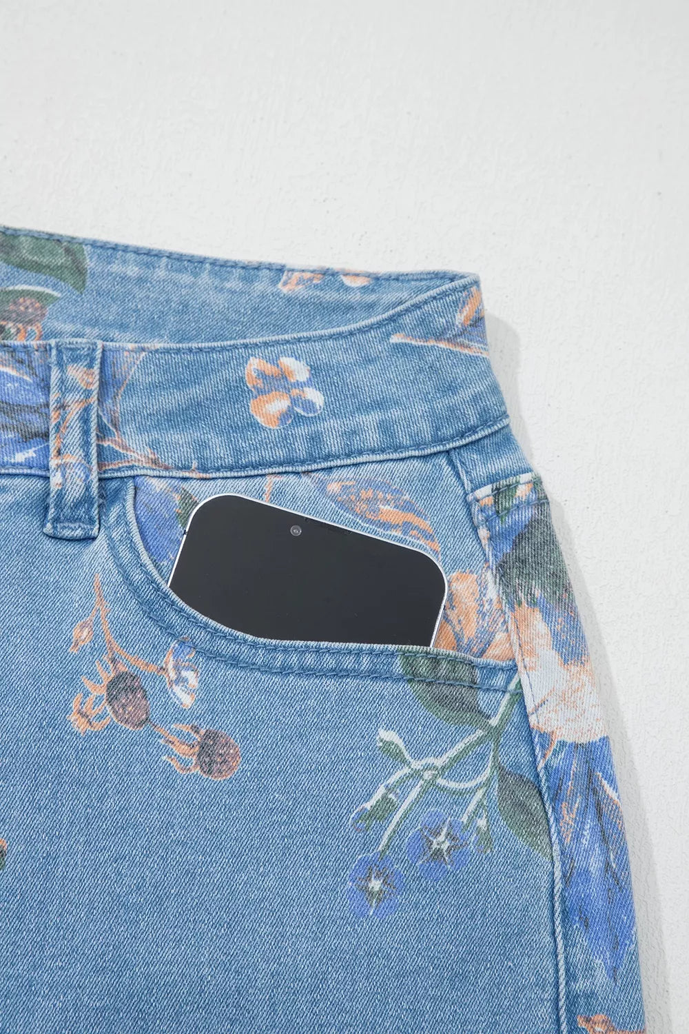 Floral print wide-leg jeans from Trendsi with vibrant floral patterns and relaxed fit, displayed on a model.