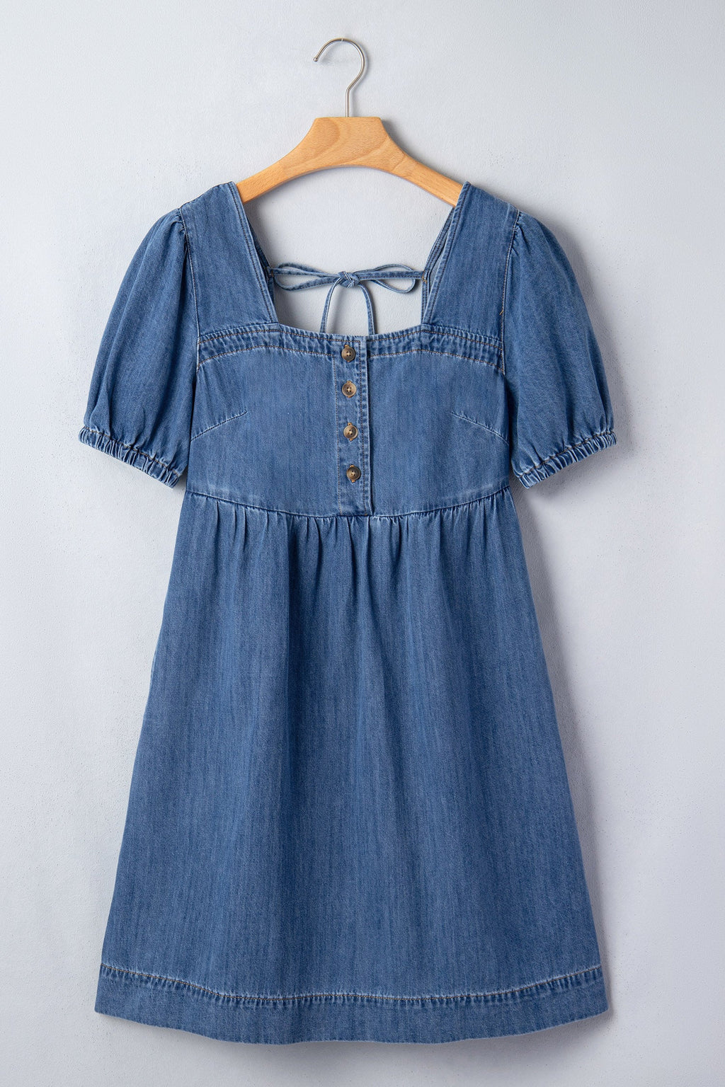 Threaded Pear Karina puff sleeve mini dress hanging on a clothing rack, featuring a fitted silhouette and stylish puff sleeves.