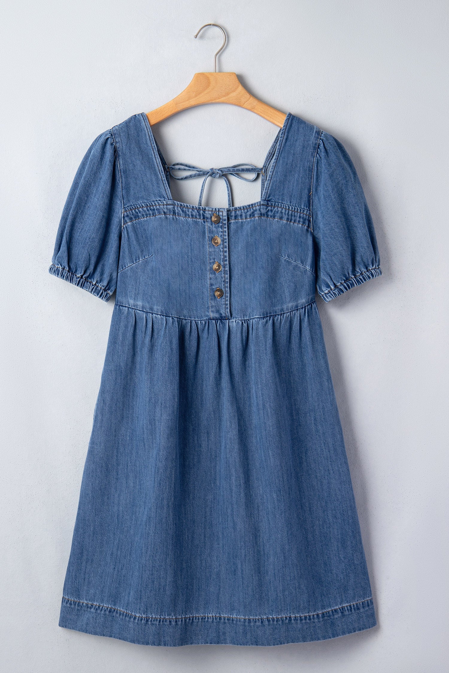 Threaded Pear Karina puff sleeve mini dress hanging on a clothing rack, featuring a fitted silhouette and stylish puff sleeves.