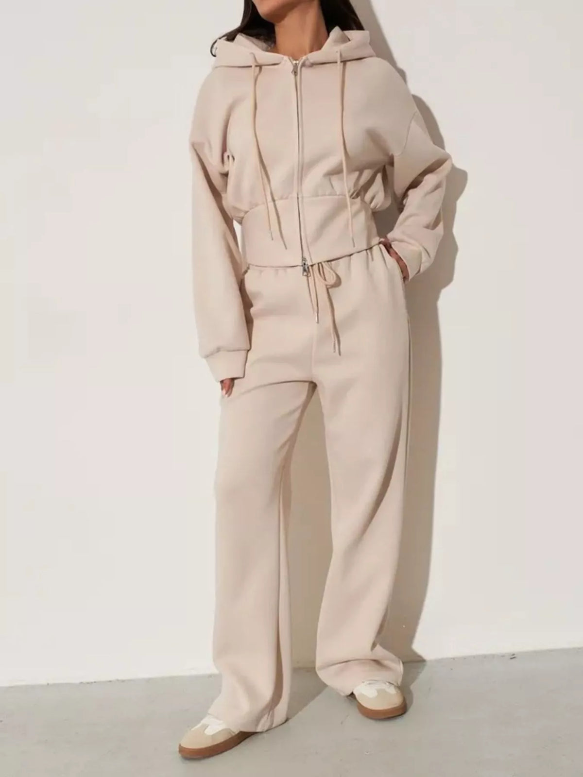 Plush Fashion Hub zip-up hoodie and wide-leg pants loungewear set, soft fabric, relaxed fit, in neutral tones, displayed on a hanger.