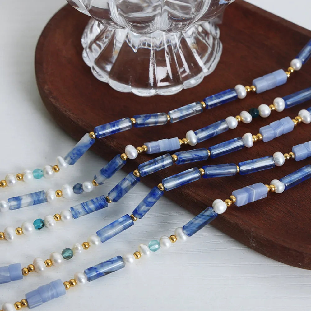 Freshwater pearl and titanium steel geometric bead necklace with modern design, featuring sleek silver tones and elegant craftsmanship.