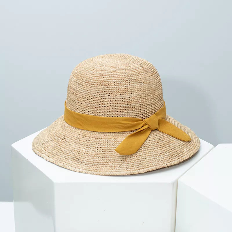 Women's straw sun hat with wide brim and ribbon detail, stylish summer accessory by Plush Fashion Hub.