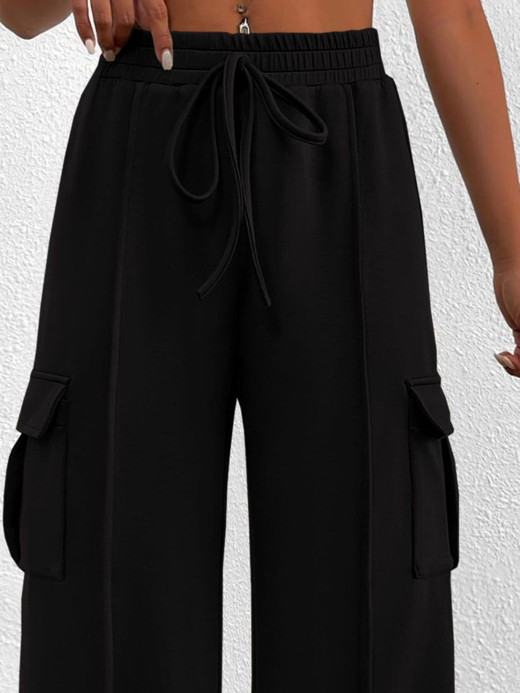 Women's high-waisted casual cargo pants with drawstring from Trendsi, lightweight utility design, featuring multiple pockets and relaxed fit.