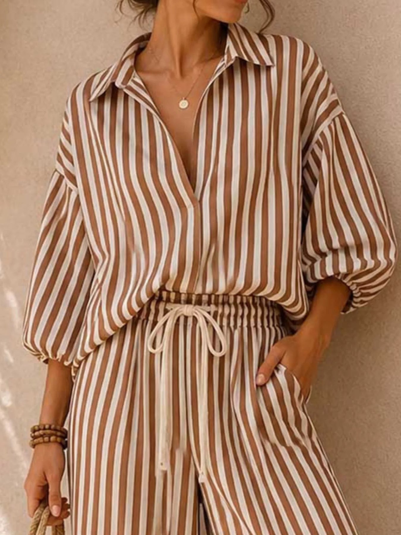 Plus size striped puff sleeve shirt and wide-leg drawstring pants set by Trendsi, featuring a casual, comfortable fit and stylish design.
