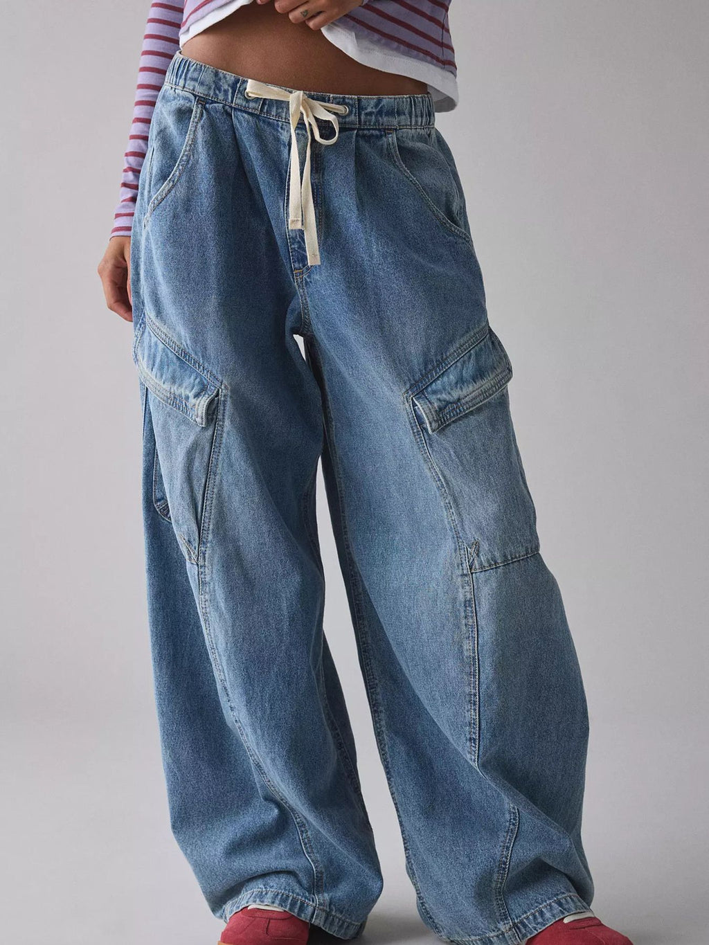 Women's relaxed fit cargo denim jeans with drawstring waist and utility pockets, styled for casual wear.