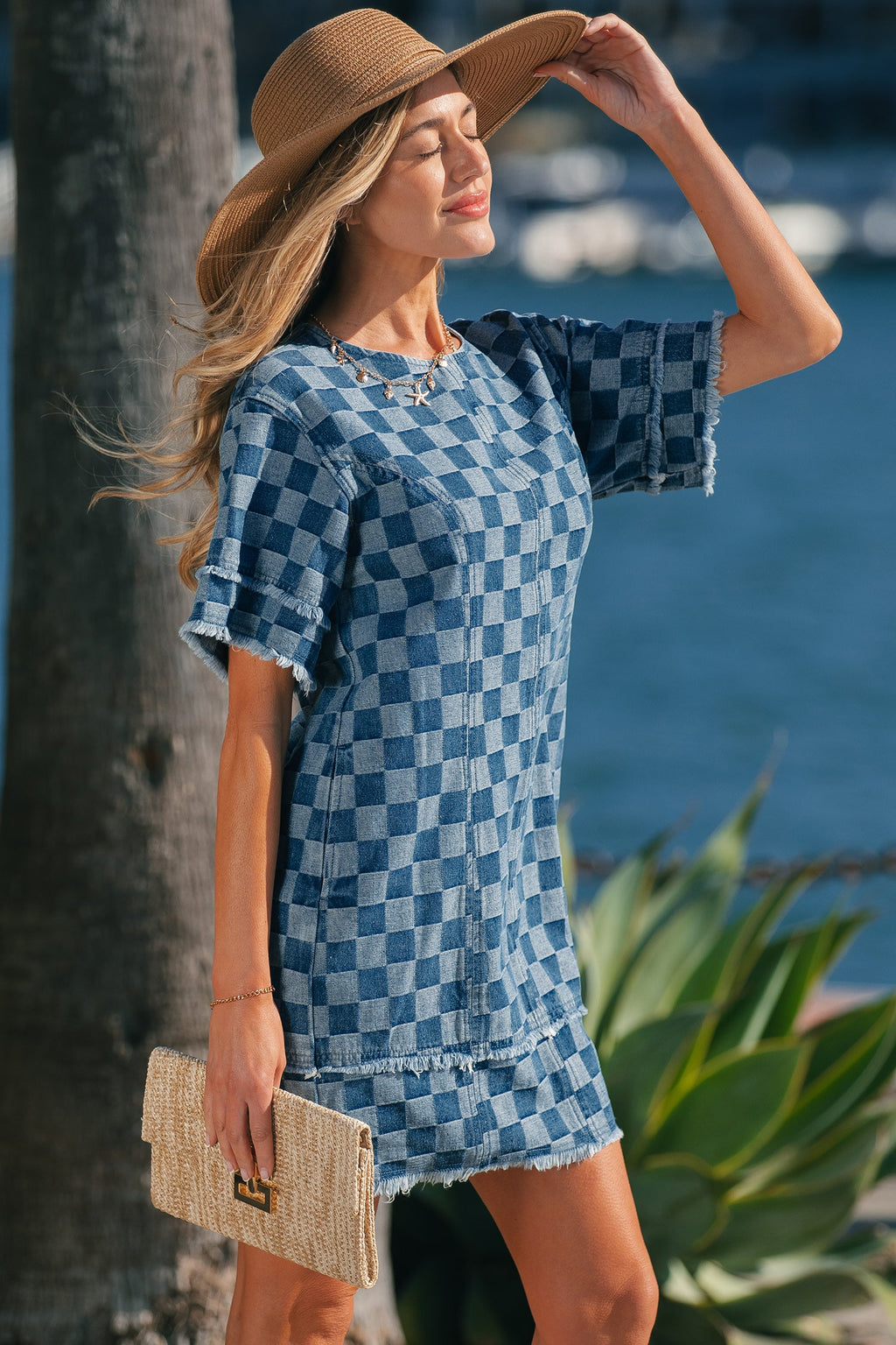 Threaded Pear Jessie Hem checkered mini dress hanging on a hanger with a fitted bodice and flared skirt.