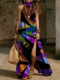 Women's printed halterneck split maxi dress in loose fit with sleeveless design, featuring vibrant patterns and flowing fabric.