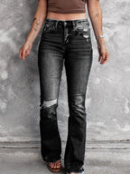Distressed flare denim jeans by Plush Fashion Shop featuring ripped details and a high-waisted fit on a model.