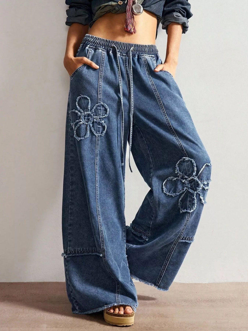 Wide leg jeans featuring floral appliques from Shopimist, showcasing intricate floral embroidery on denim fabric.