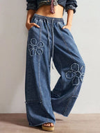 Wide leg jeans featuring floral appliques from Shopimist, showcasing intricate floral embroidery on denim fabric.