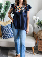 Women's embroidered floral ruffle sleeve blouse by Trendsi, lightweight and elegant, featuring delicate floral embroidery and ruffle details.