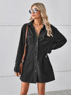 VYSN pocketed dropped shoulder mini denim dress hanging on a hanger showcasing its relaxed fit and stylish design.