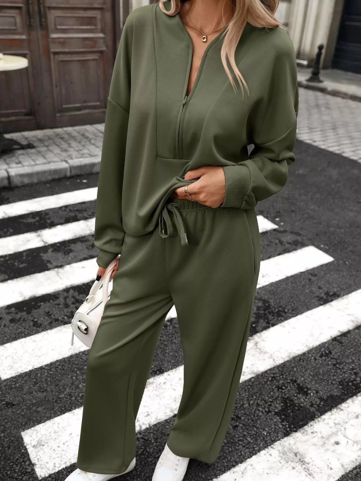 Women’s half zip sweatshirt and wide-leg pants set by Trendsi, featuring a cozy top and flowing pants in a stylish matching ensemble.
