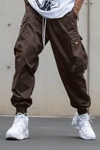 Men’s multi-pocket drawstring cargo pants in streetwear style by Plush Fashion Hub, featuring multiple pockets and a relaxed fit.
