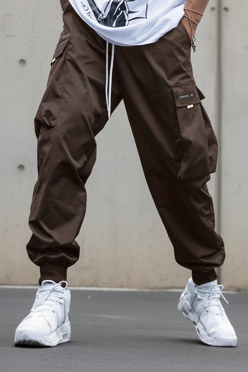 Men’s multi-pocket drawstring cargo pants in streetwear style by Plush Fashion Hub, featuring multiple pockets and a relaxed fit.