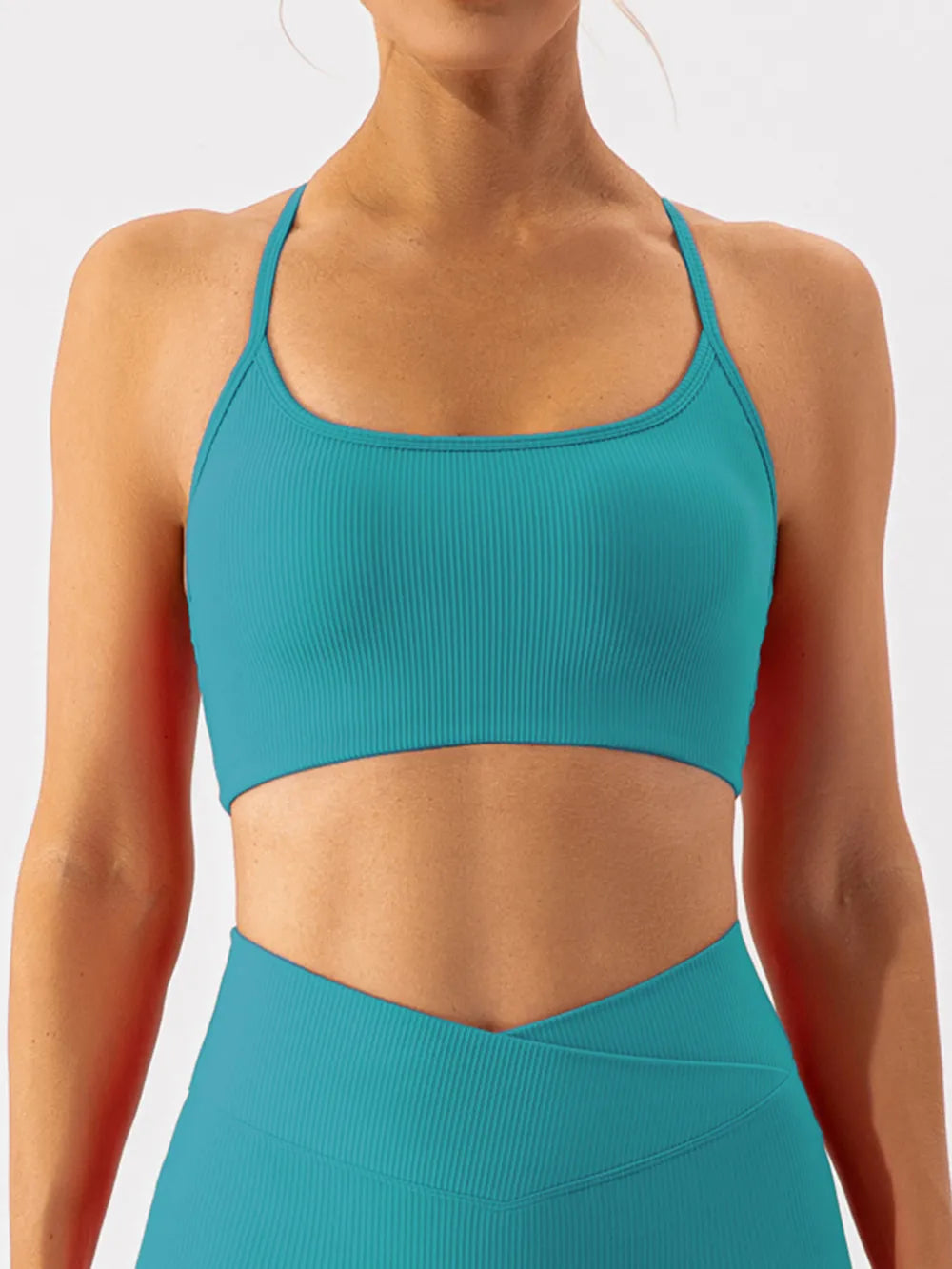 Black spaghetti strap active bra from Trendsi, featuring a sleek design and adjustable straps for comfortable workout wear.