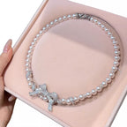 Elegant pearl necklace from Shopimist featuring a delicate bow pendant, perfect for sophisticated jewelry styling.