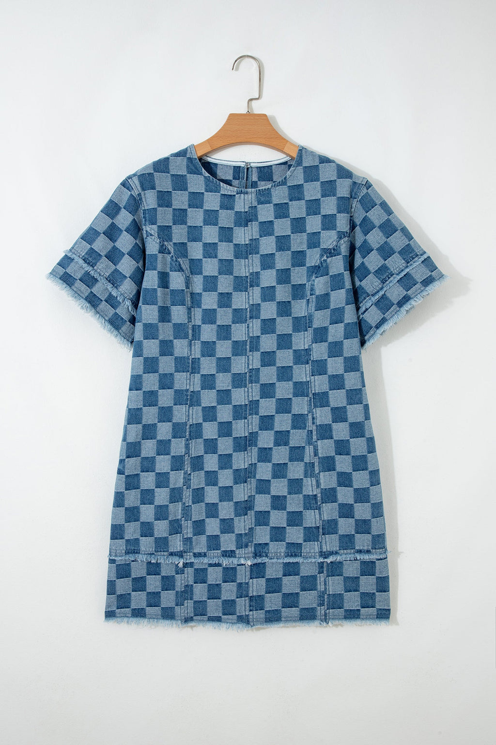Threaded Pear Jessie Hem Checkered Mini Dress hanging on a hanger, showcasing its stylish checkered pattern and mini length.