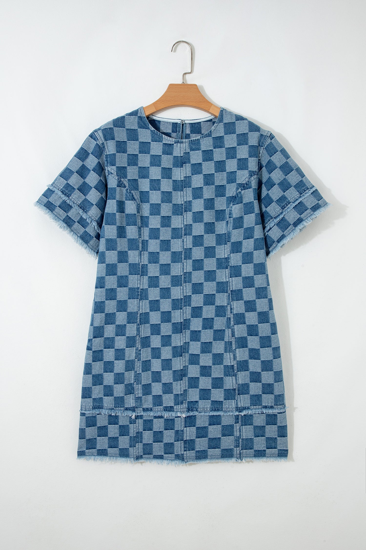 Threaded Pear Jessie Hem Checkered Mini Dress hanging on a hanger, showcasing its stylish checkered pattern and mini length.