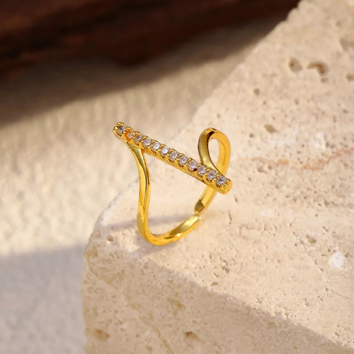 Close-up of Plush Fashion Hub's irregular rhinestone ring with sparkling, uneven design and silver band on a white background.