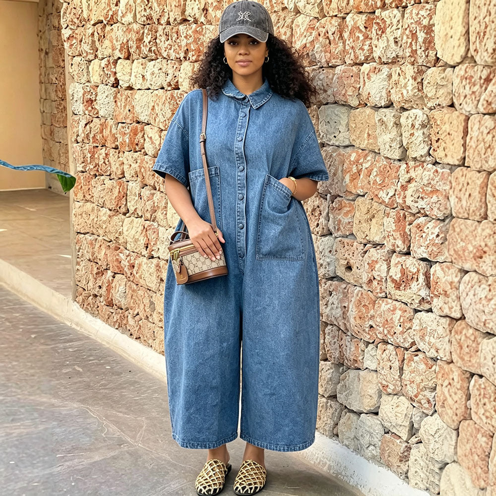 Washed denim women’s short sleeve jumpsuit with single button closure, loose fit, one-piece design by Plush Fashion Hub.