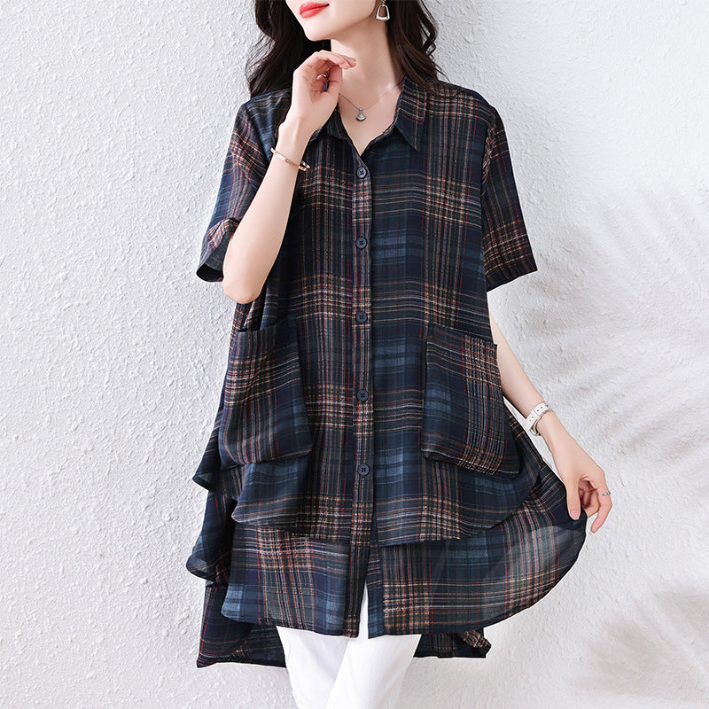 A blue plaid button-down tunic with short sleeves, a collar, and two front pockets in a layered handkerchief-hem style.