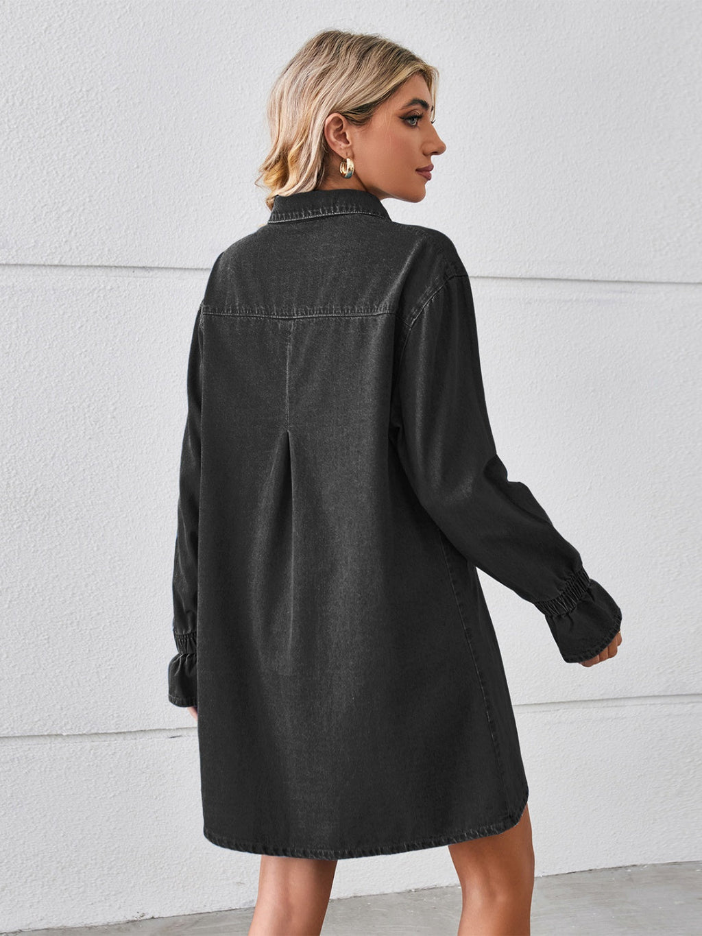 VYSN pocketed dropped shoulder mini denim dress displayed on a hanger, showcasing its relaxed fit and stylish design.