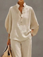 Plus size women's two-piece dress set with button details and 3/4 sleeves, featuring a stylish top and matching pants from Trendsi.