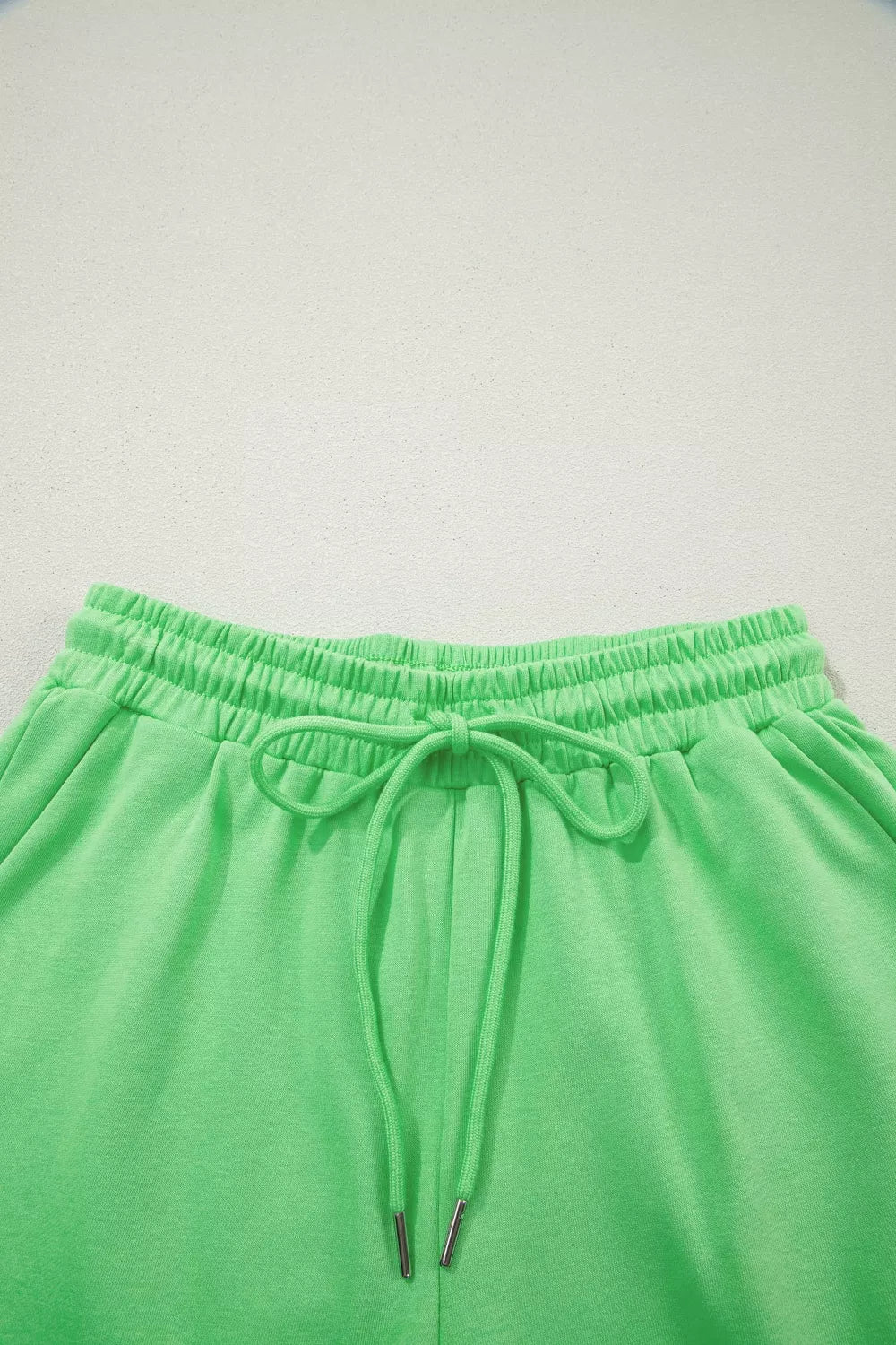 Pair of trendy solid color puffy loose drawstring shorts and rings from Trendsi, shown in a stylish 2-piece outfit.