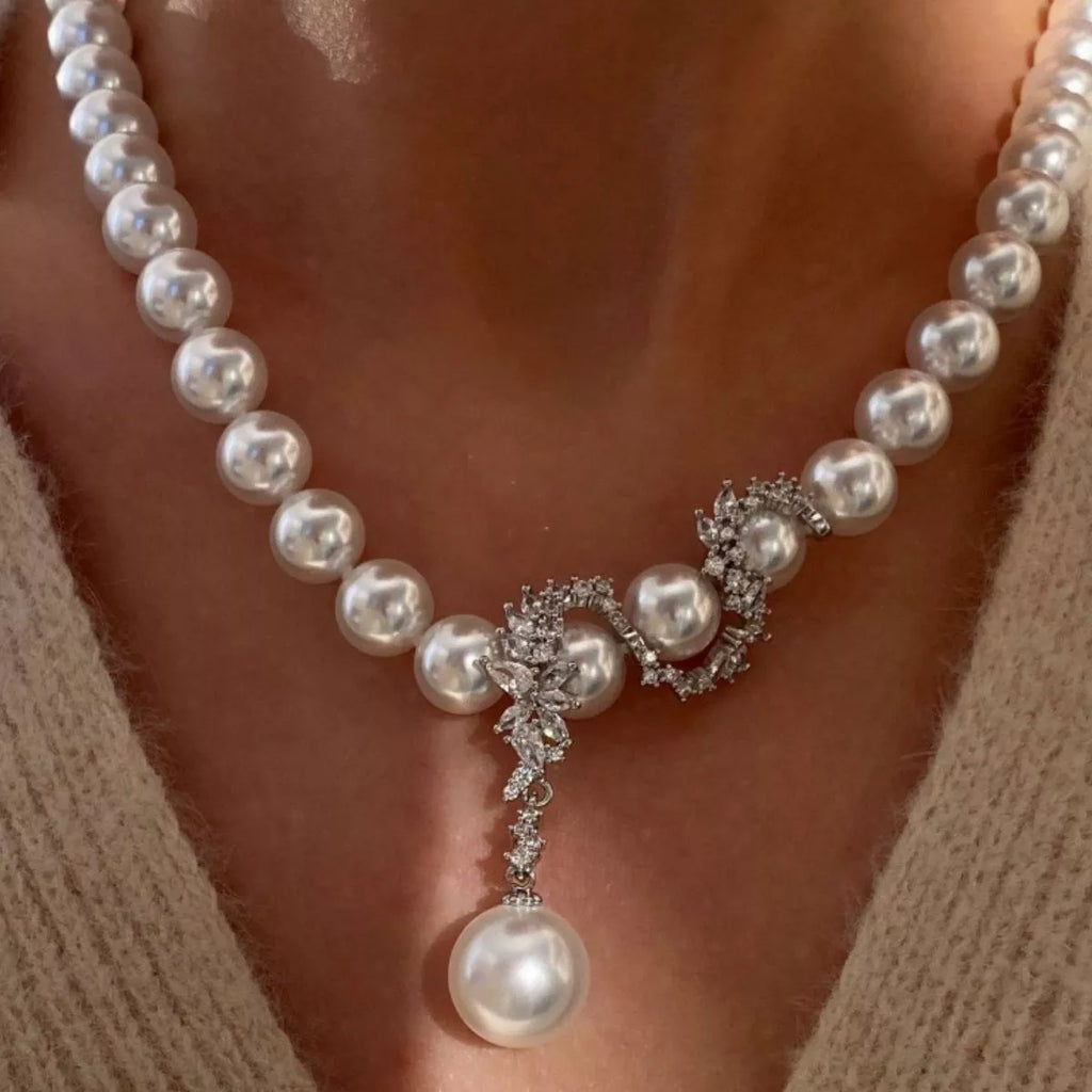 Elegant zircon pearl necklace featuring lustrous pearls and sparkling zircon accents, styled on a delicate chain.