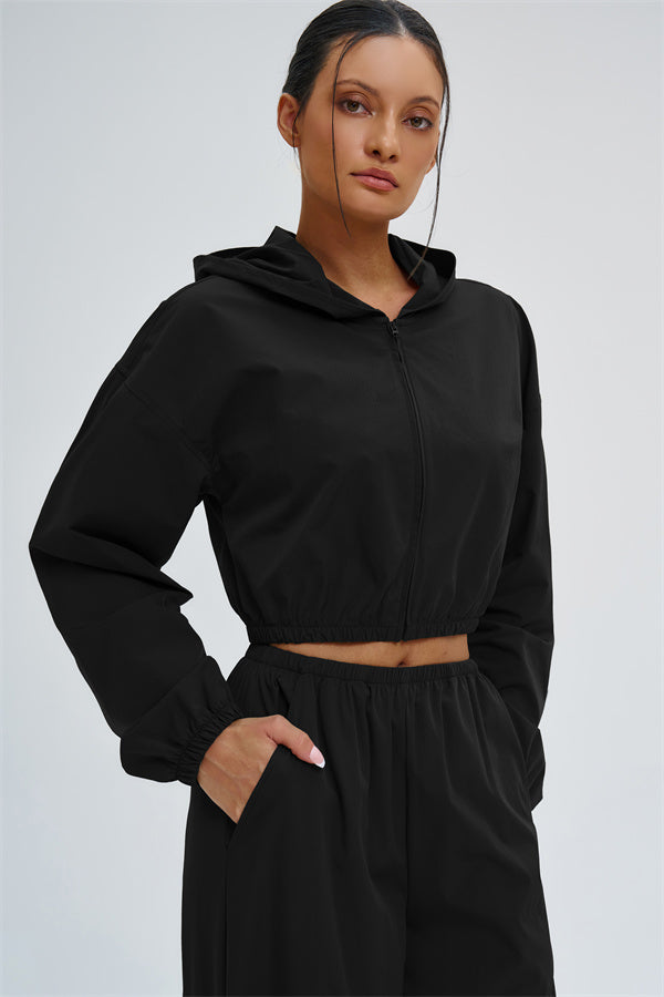 A Fitglutes Activewear UV protection crop hoodie in black, featuring a fitted design, long sleeves, and a hood for active gym workouts.