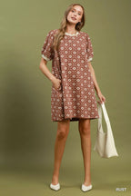 Umgee floral textured puff sleeve mini dress displayed on a hanger, showcasing the detailed fabric and stylish design.
