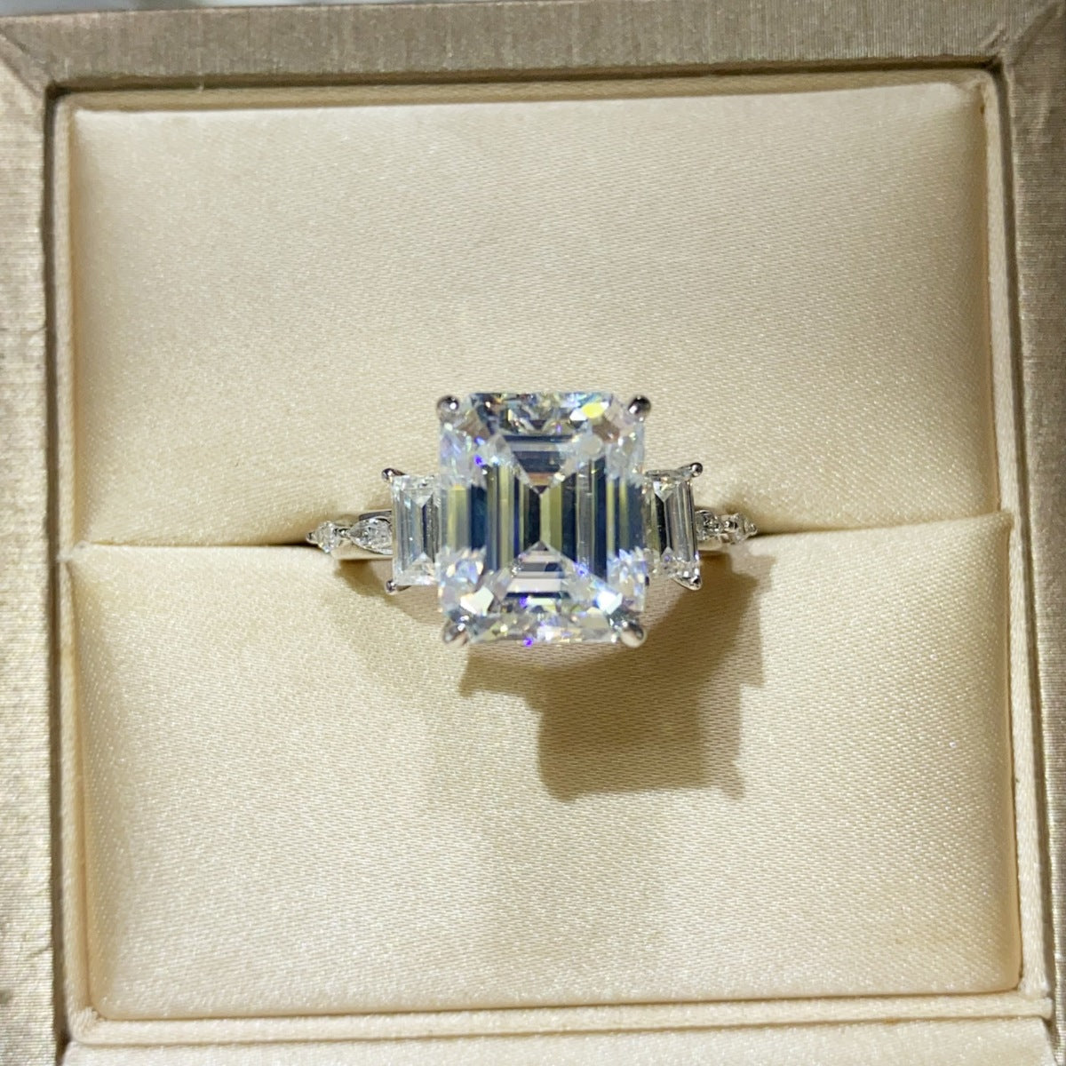 Sterling silver ring with a 5-carat moissanite gemstone, featuring a sleek band and sparkling centerpiece.