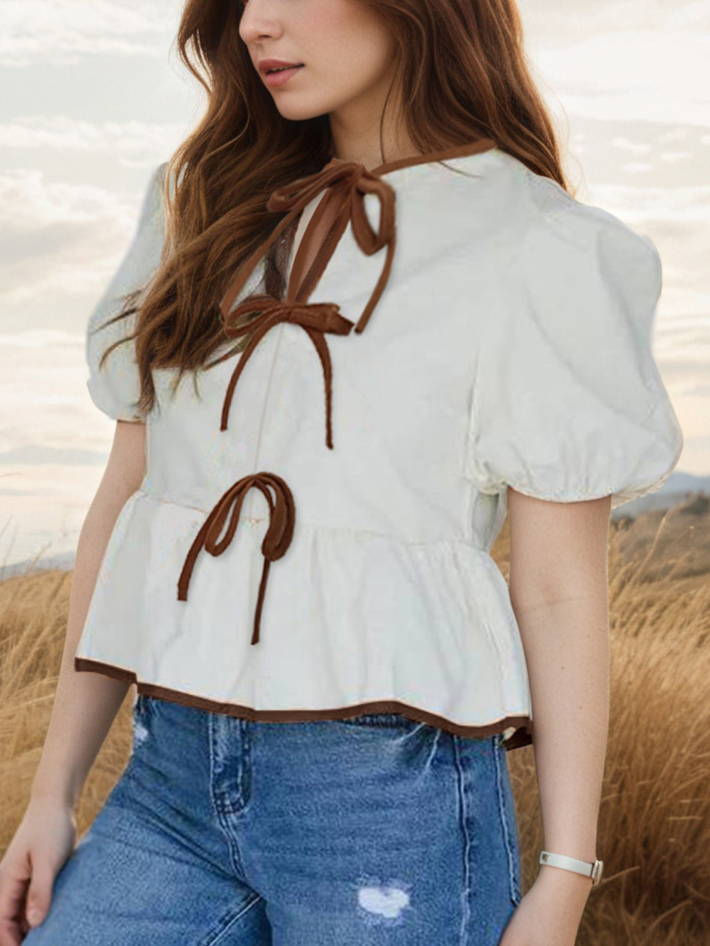 Elegant white blouse with tie-front, puff sleeves, and peplum style, perfect for stylish outfits.